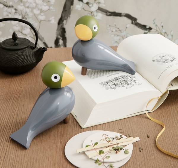 2 Nachtigallen - Vögel aus grau lackiertem Buchenholz mit grünem Kopf und gelbem Schnabel aus der Serie Kay Bojesen Singvögrel - Dekofoto mit Buch