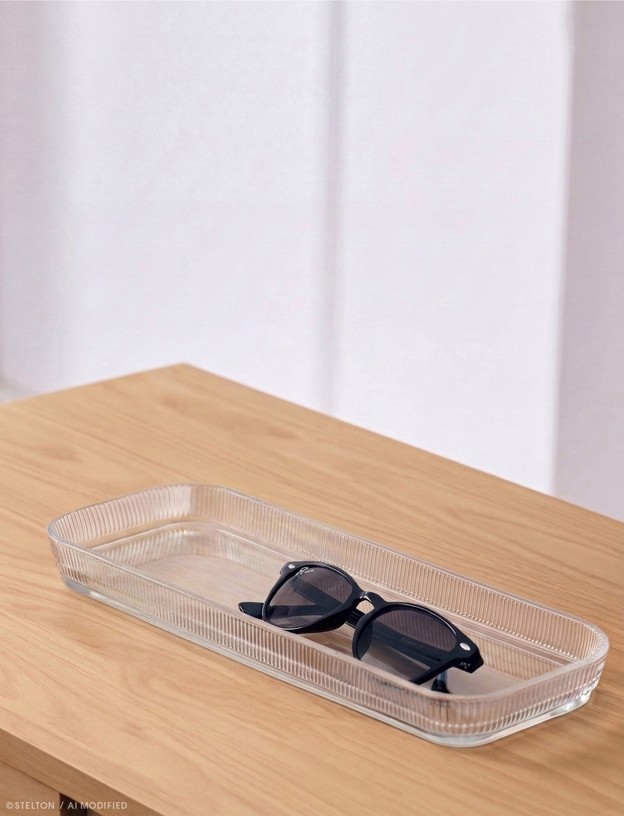 Stelton Pilastro Servierplatte aus klarem Rillenglas mit Sonnenbrille auf einem Holztisch